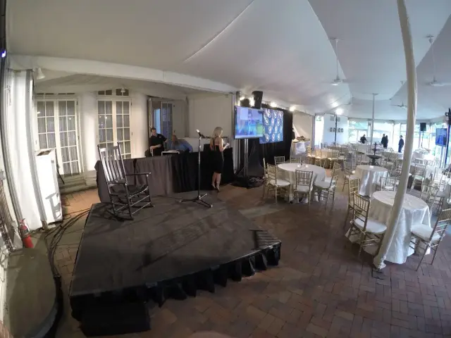 Indoor event setup with stage, microphone, and tables.